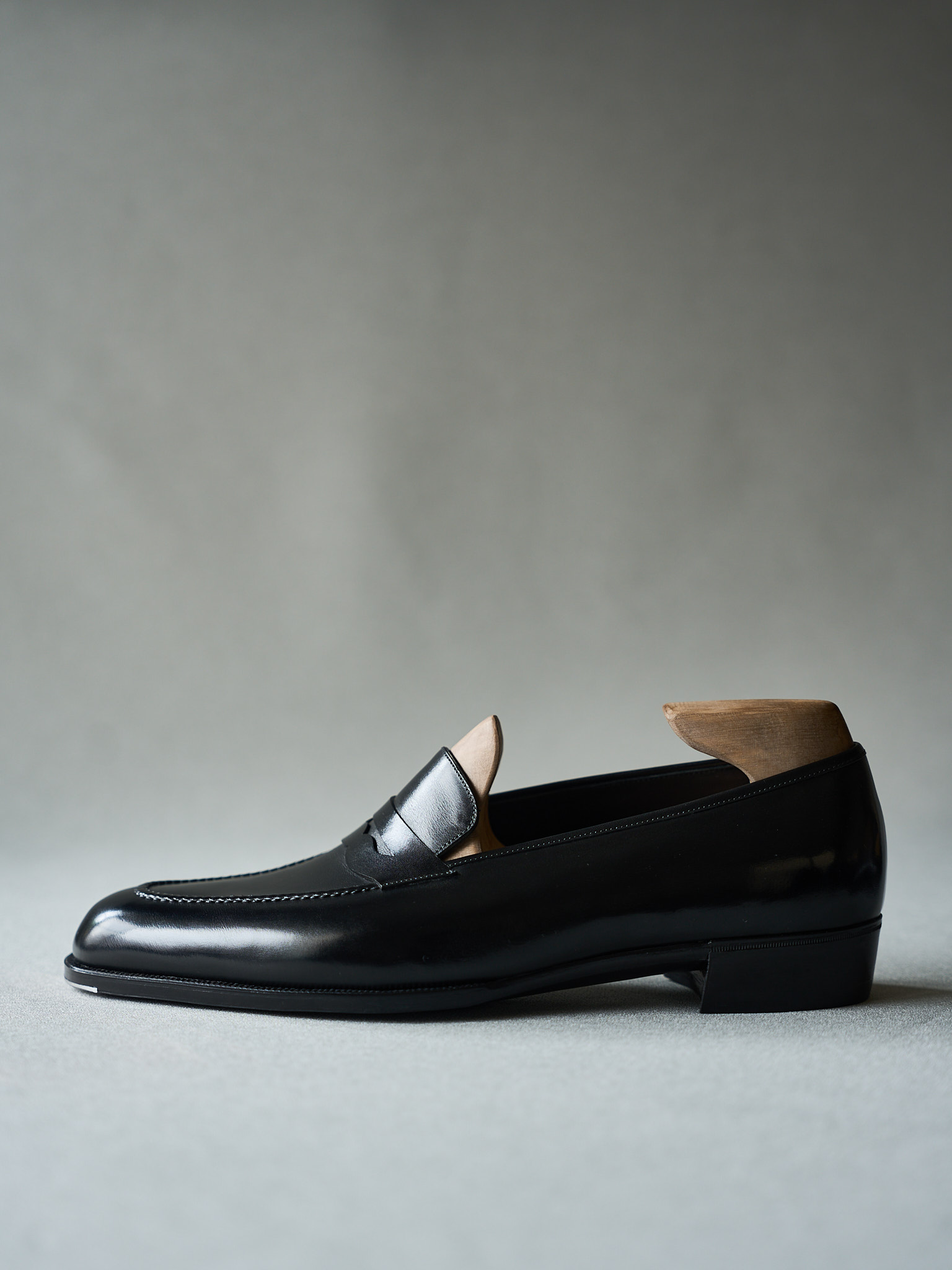 Black leather loafer with polished finish and classic saddle band design.